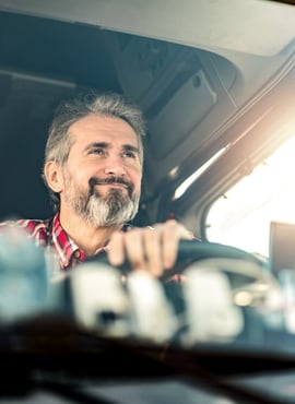 smiling trucker on the road - physical damage insurance