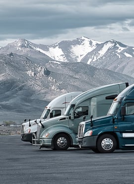 Three semi trucks in front of mountains - risk financing