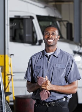 Garage worker smiles as he wipes his hands